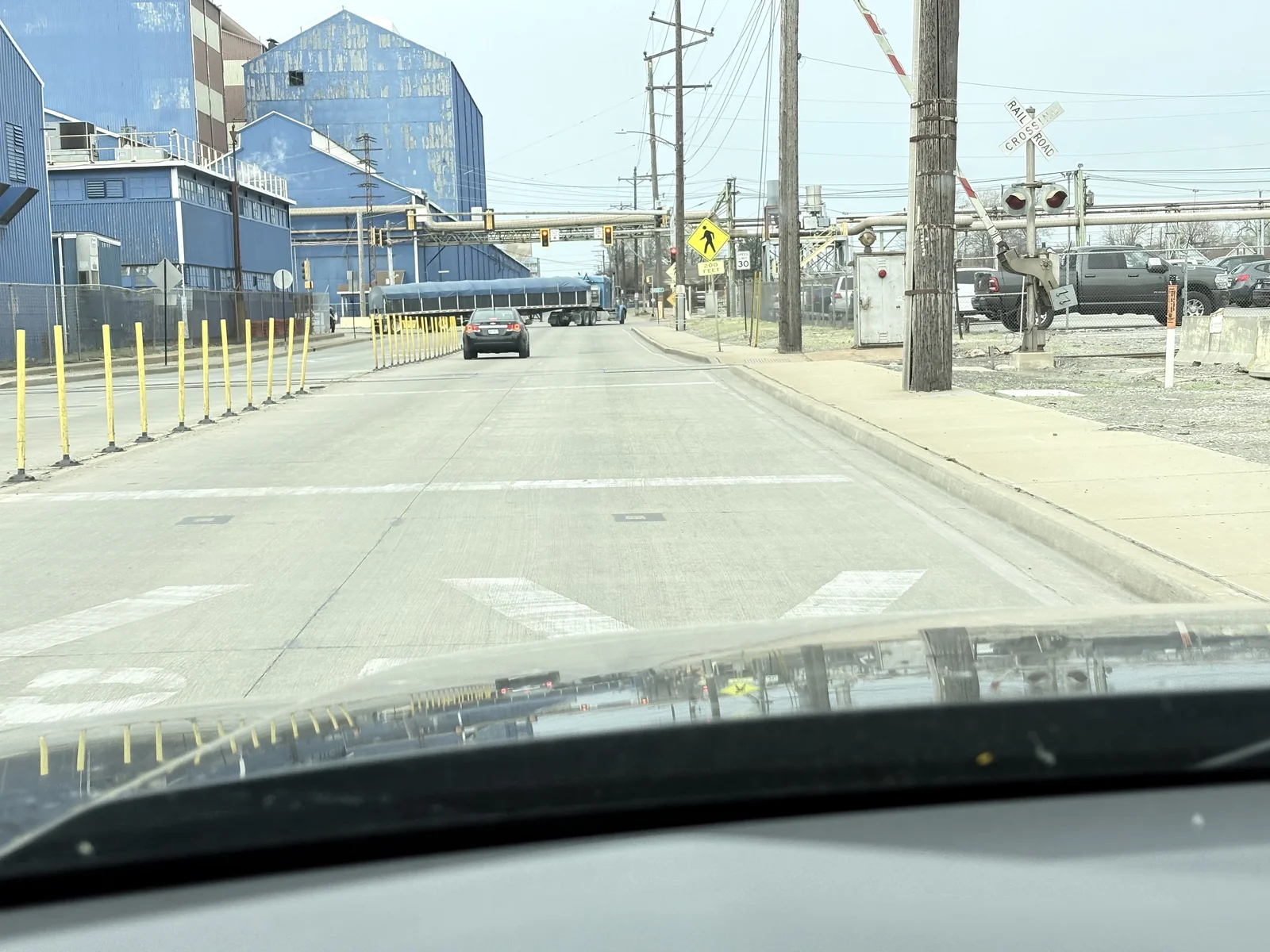 Looking out the windshield of my truck driving down a side street past the old steel mill facilities.