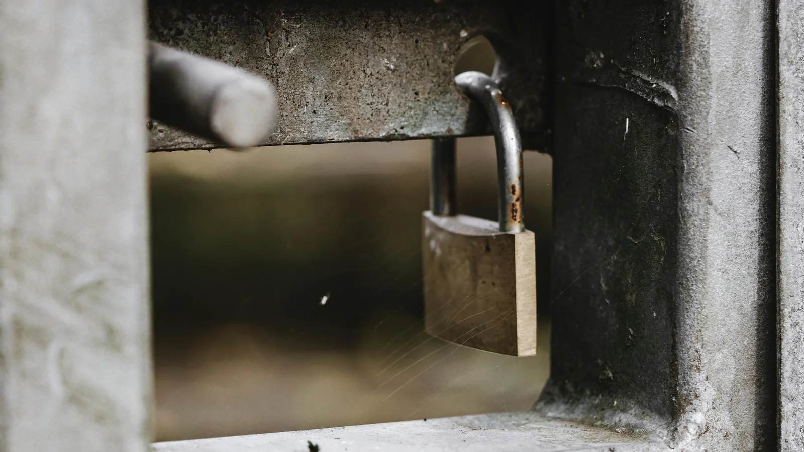 Stock photo of a padlock on the bolt of a gate handle.