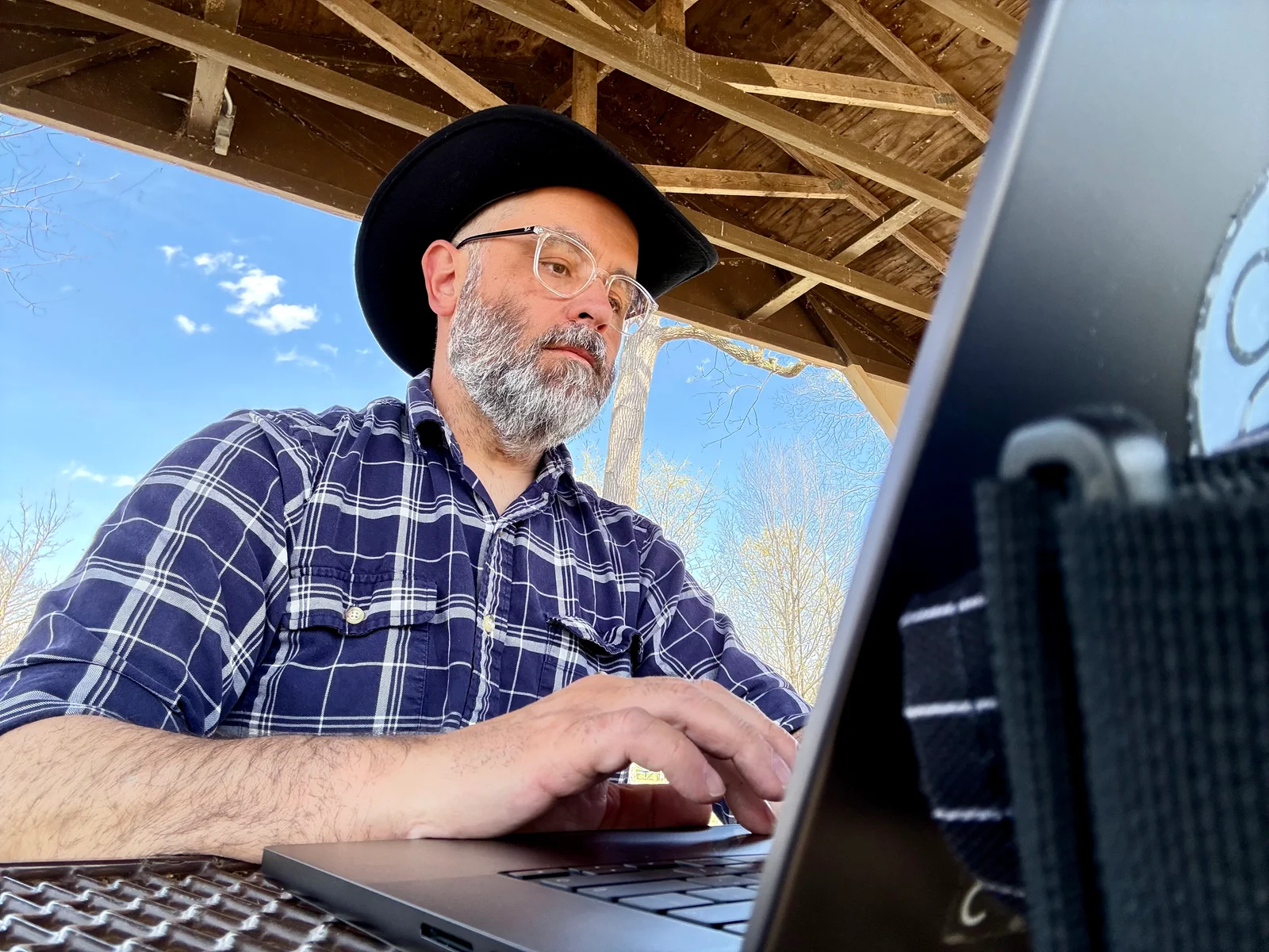 Working at a picnic table on the laptop.
